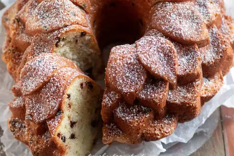 Una deliziosa torta al mascarpone con gocce di cioccolato, spolverata di zucchero a velo, pronta per essere gustata.