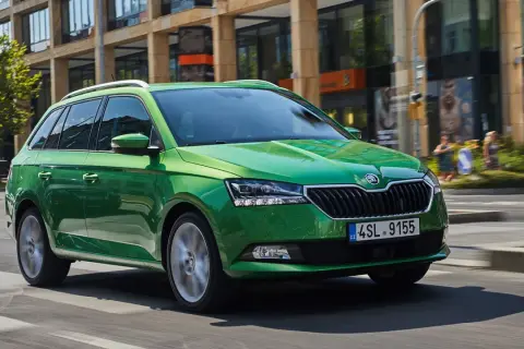 Grön Skoda Fabia kombi kör på stadsgata. Vissa modeller kan ha skoda fabia kamkedja problem.