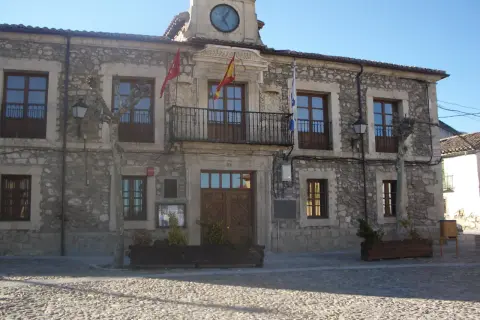 Ayuntamiento de Lozoyuela, con su fachada de piedra, balcón y reloj. Un lugar con mucho que ver.