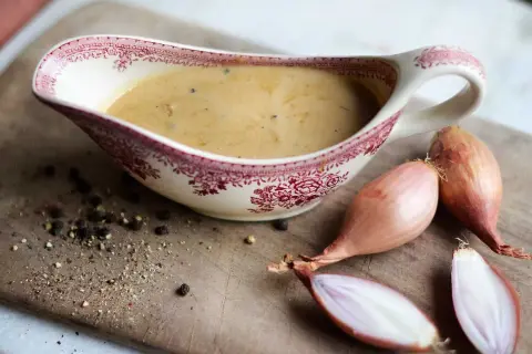 Enkel pepparsås recept med schalottenlök och nymalen svartpeppar i en vacker såssip.