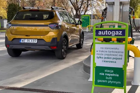 Żółty Dacia Sandero Stepway na stacji autogazu. Kierowca sprawdza dacia sandero stepway spalanie przed tankowaniem.