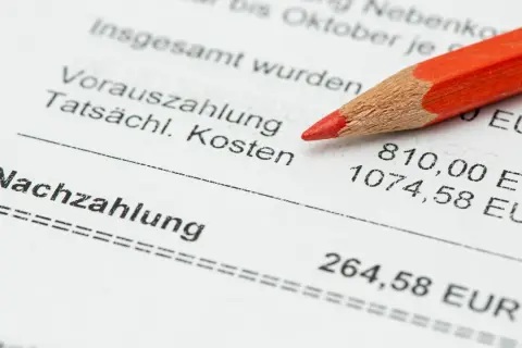 Roter Bleistift auf Nebenkostenabrechnung. Die Nachzahlung ist 264,58 EUR. Fristen für die Nebenkostenabrechnung beachten.