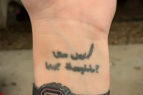 Tatuaz na opalonej skorze z napisem "Who would have thought?".
