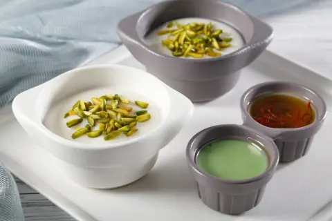 Douceurs crémeuses, pistaches croquantes et sirops colorés pour une mouhalabieh recette parfaite.
