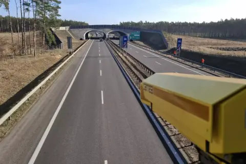 Żółta kamera rejestruje prędkość na drodze. To system odcinkowy pomiar prędkości, który dba o bezpieczeństwo kierowców.