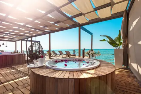 Luksusowy jacuzzi z płatkami róż na tarasie z widokiem na morze. Idealne miejsce na relaks w stylu ultra all inclusive.