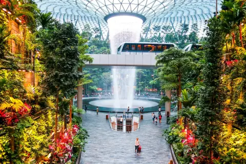 Im **Singapore Flughafen** erwartet Reisende eine üppige Oase mit einem beeindruckenden Wasserfall und einer Monorail, die durch tropische Vegetation fährt.