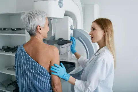 Lekarka przygotowuje pacjentkę do mammografii. Czy mammografia boli? To badanie jest ważne dla zdrowia.