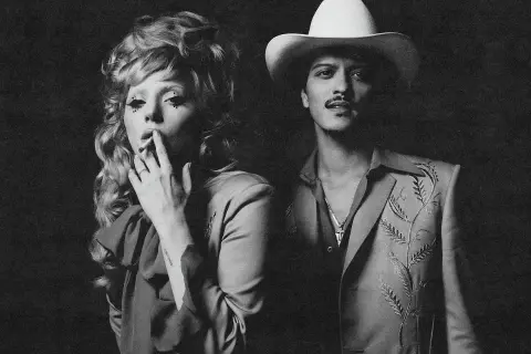 Lady Gaga z papierosem i Bruno Mars w kapeluszu. Tekst "die with a smile" idealnie pasuje do ich stylizacji.
