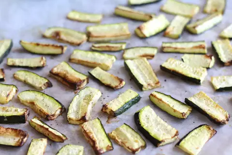 Skivor av zucchini i ugn, lätt gyllene och kryddade, redo att serveras.