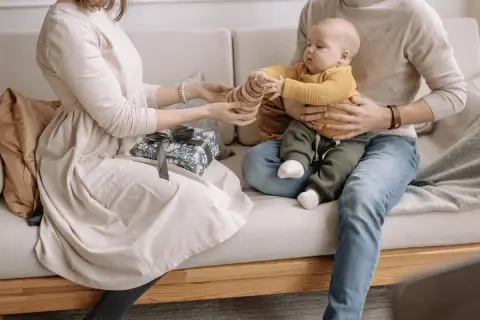 Un couple heureux profite de son enfant, un cadeau emballé à côté.