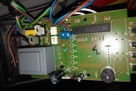 Sterownik Atos jak ustawić? Widok płytki drukowanej z elementami elektronicznymi, przewodami i przekaźnikiem.