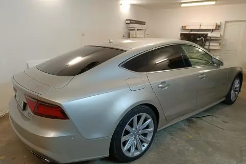 Srebrne Audi A7 z przyciemnione szyby stoi w garażu.