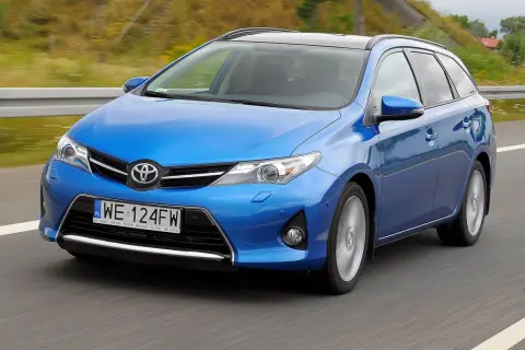 Niebieski Toyota Auris 2015 na drodze, z rozmytym tłem.