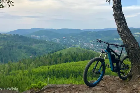 Rower górski czeka na przygodę na trasie rowerowej Skoczów Wisła. Widok na Beskidy zapiera dech w piersiach.