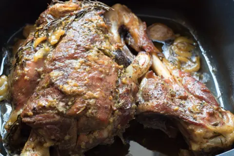 Succulento agnello al forno, dorato e profumato con rosmarino e aglio, pronto per essere gustato.