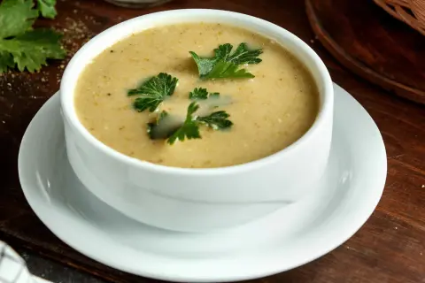 Aksamitna zupa na wielkanoc, udekorowana świeżą natką pietruszki, czeka na świątecznym stole.