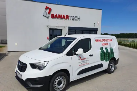 Biały van z logo BAMARTECH i grafiką oczyszczalni ścieków. Firma oferuje serwis, odpowiadając na pytanie: jak często trzeba opróżniać przydomową oczyszczalnię ścieków przepisy.