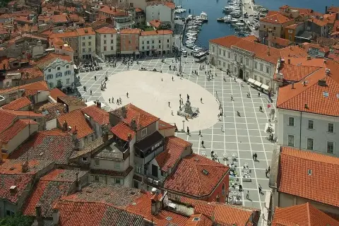 Słowenia morze: malowniczy plac w Piran, z widokiem na dachy i port.