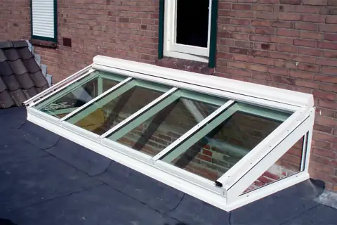 Monteras para patios, un tragaluz moderno de vidrio y aluminio sobre un tejado, ilumina el interior con luz natural.