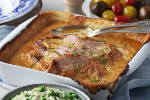 En krämig kasslergratäng med gyllene yta, garnerad med färska örter. Ett perfekt kassler recept för en mysig middag.