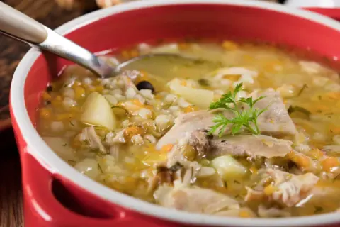 Gorący krupnik, przepis babci, z kawałkami mięsa, ziemniaków i kaszy pęczak, ozdobiony natką pietruszki.