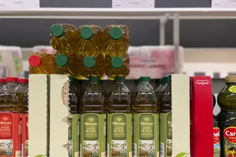 Botellas de aceite de oliva en estanterías. Las desventajas del aceite de oliva, como su precio, pueden ser un factor a considerar al comprar.