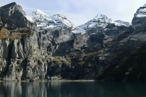 Majestatyczne Tatry Wysokie, ośnieżone szczyty odbijające się w spokojnej tafli jeziora.