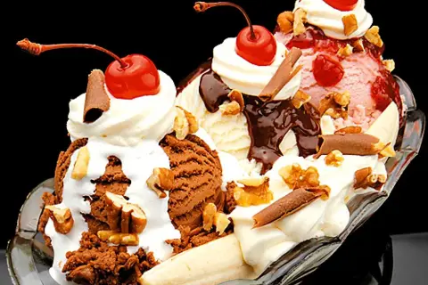 En klassisk banana split med tre kulor glass, banan, grädde, chokladsås, nötter och körsbär. Ett perfekt banana split recept för en varm dag.