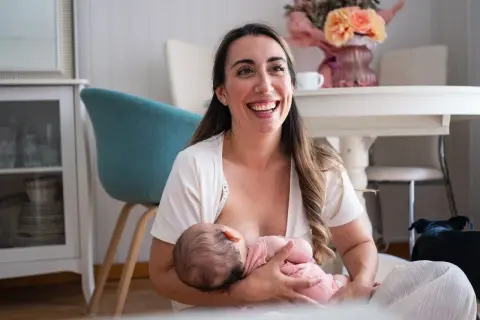 Szczęśliwa mama karmi piersią dziecko, pokazując jedną z wielu zalet karmienia piersią.