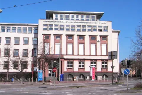 Die Fachhochschule Frankfurt am Main – University of Applied Sciences, kurz ESM Frankfurt am Main, zeigt sich in heller Fassade mit vielen Fenstern.
