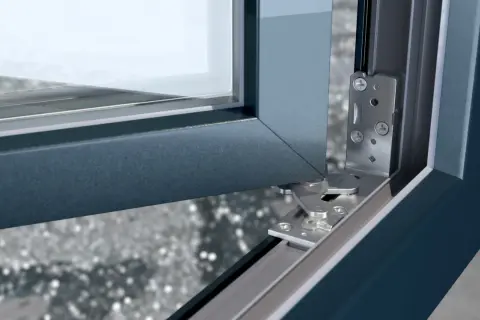 Mechanizm drzwi balkonowych nie chce się zamknąć. Widoczny metalowy zawias i fragment ramy okiennej.