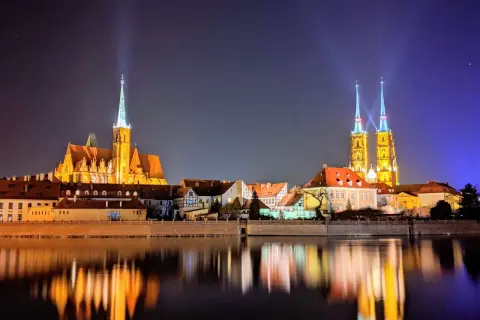 Beleuchtete Kathedralen spiegeln sich im Wasser. Ein perfekter Anblick nach einer Wrocław free walking tour.