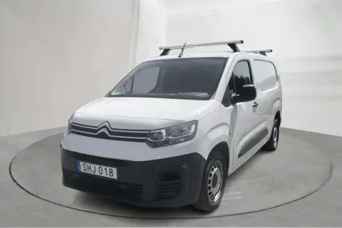 Vit Citroën Berlingo, en pålitlig begagnad transportbil med takräcke, redo för nya äventyr.