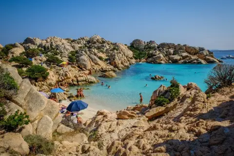 Spiagge del nord Sardegna: un angolo di paradiso con rocce granitiche, acque cristalline e bagnanti che si godono il sole.