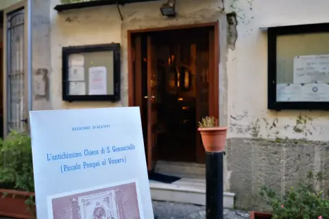 Un cartello annuncia "L'antichissima Chiesa di S. Gennariello (Piccola Pompei al Vomero)" davanti a un ingresso antico.
