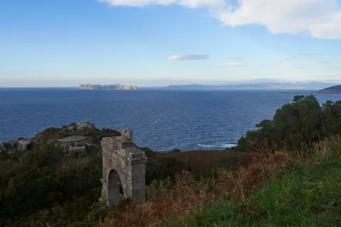 Ruinas de un antiguo faro silleiro, con el mar azul y las islas Cíes al fondo.