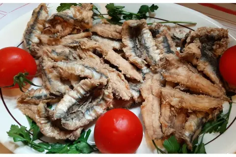 Chrupiące filet anchois z sardeli, podane z pomidorami i natką pietruszki. Pyszna przekąska.