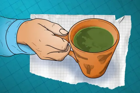 En hand håller en kopp grönt te. Finns det koffein i te? Ja, det gör det, men mindre än i kaffe.