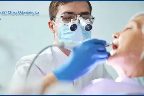 Dentista con lente d'ingrandimento esamina la bocca di un'anziana, garantendo un'accurata igiene orale anziani.