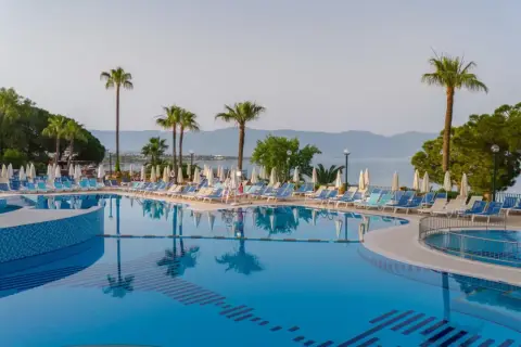 Basen z leżakami i palmami, idealne miejsce na wakacje w Fantasia De Luxe Kusadasi.
