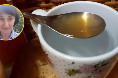 Kobieta z uśmiechem na twarzy pokazuje łyżkę z wodą z octem jabłkowym, gotową do wypicia.