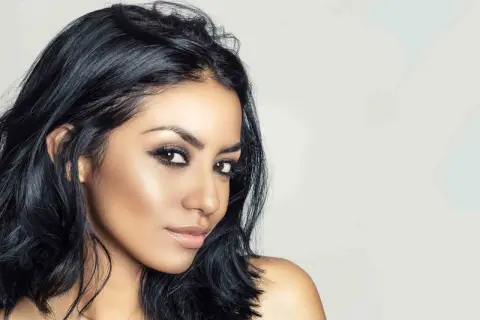 Mujer con piel morena, ojos marrones y un color de pelo azabache que resalta su belleza natural.