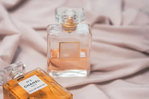 Dwie ikoniczne butelki perfum Chanel, N°5 i Coco Mademoiselle, na jedwabistym tle. Klasyka, która nigdy nie wychodzi z mody, jak Chanel Noir.