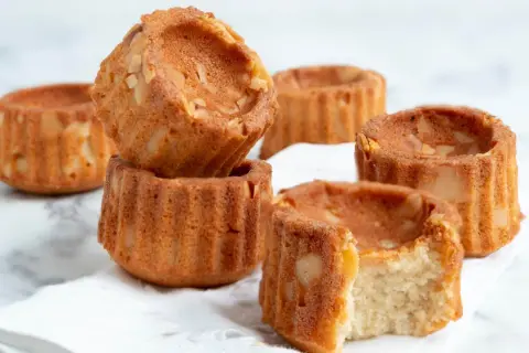 Små, gyllene financiers med mandelbitar, perfekta för ett enkelt financier recept. En tugga avslöjar en saftig insida.