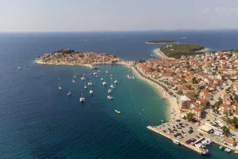 Malownicza Chorwacja, idealna na wakacje dojazd własny. Widok na miasteczko z czerwonymi dachami, zatokę pełną łodzi i plażę.