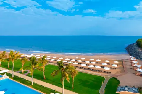 Piękna plaża z palmami i basenem, idealne miejsce na wakacje. Barcelo Mussanah Resort opinie potwierdzają rajski wypoczynek.