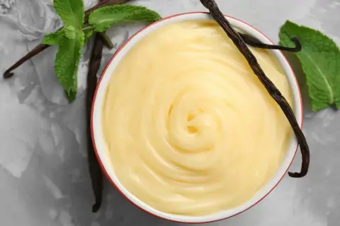 Crema pastelera sin azúcar, cremosa y suave, con vainas de vainilla y hojas de menta fresca.
