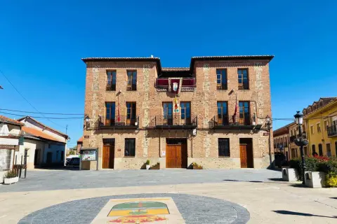 Ayuntamiento de ladrillo en plaza soleada, ideal para descubrir pueblos con encanto para comer cerca de Madrid.