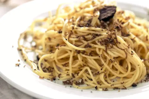 En tallrik med spaghetti, generöst toppad med finriven tryffel. Perfekt för en lyxig middag med ett gott vin till tryffelpasta.